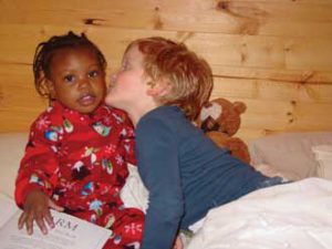 Five-year-old Max Engle-Warnick gives his new sister Esther a kiss just days after her arrival to Montreal from Haiti. Three-year-old Esther was adopted by economics professor Jim Engle-Warnick and his wife Jayne. 