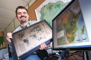 Bernhard Lehner holds the digital version of his one-of-a-kind map of the world's rivers that will be featured in the April 2010 "Fresh Water" issue of National Geographic magazine. / Photo: Owen Egan 