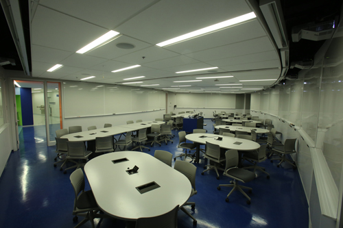 One of CyberMed’s three Active Learning Classrooms. Each room has 16 projectors, which are hard-wired to every table so that students can share their work and ideas on any or all of eight porcelain white boards that do double-duty as both projection and writing surfaces. / Photo: Owen Egan. 