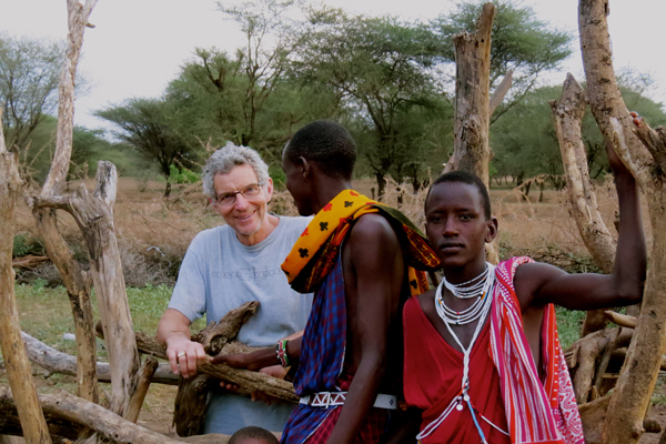 McGill geography professor Thom Meredith speaks with young Maasai men at the border of a "boma" on the Olkiramatian Group Ranch located at the base of the East African Rift Valley in Kenya. / Photo: Siobhan Lazenby