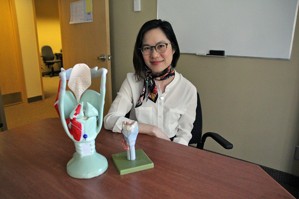 Chronic voice problems are often a combination overuse and bad vocal habits, says Nicole Li, seen here with with two larynx models. / Photo: Neale McDevitt