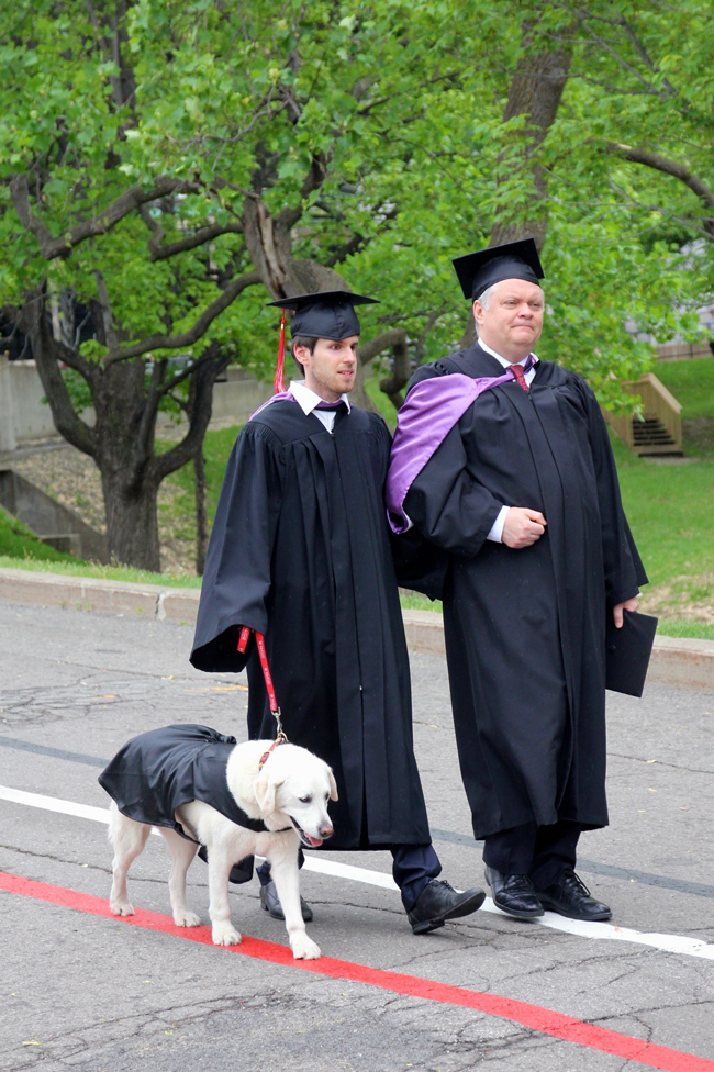 Thibault Trancart, Richard Donovan and Fiona the service dog, make their way to the Desautels Convocation Ceremony earlier today. / Photo: Neale McDevitt