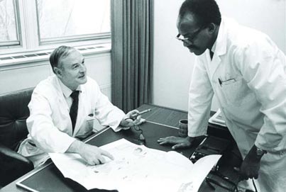 Dr. Douglas Cameron, director of McGill’s educational program with University College Nairobi, speaks with one of the Kenyan doctors who studied at McGill. Credit: McGill University Archives (PR031373)