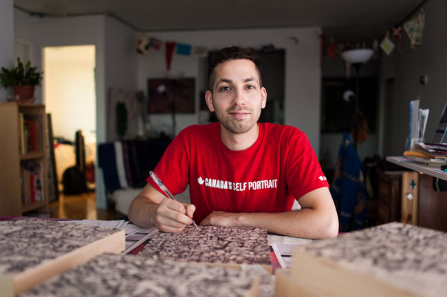 Aquil Virani works on one of the birch wood panels used to create Canada Self Portrait. / Photo: Alex Tran