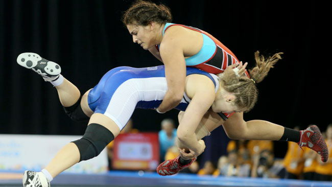 Dori Yeats (blue singlet) takes down Maria Acosta of Venezuela en route to a dominating win in the gold medal match at the Pan Am Games. / Photo: Mike Ridewood and the Canadian Olympic Committee