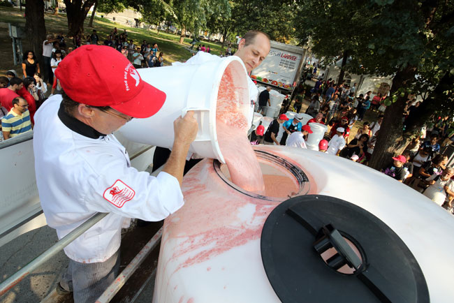 Members of Food and Dining Services top off the giant smoothie that eventually weighed in at a world-record 3,100 litres. / Photo: Owen Egan