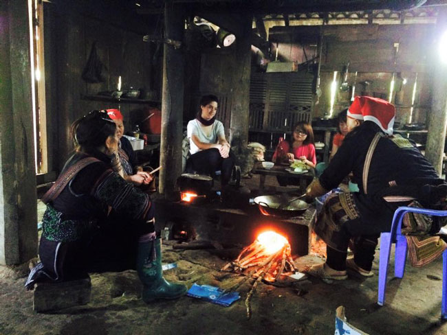 Enrica Ferrarotti eats lunch with a Red Dao minority family in a village near Sapa, North Vietnam.