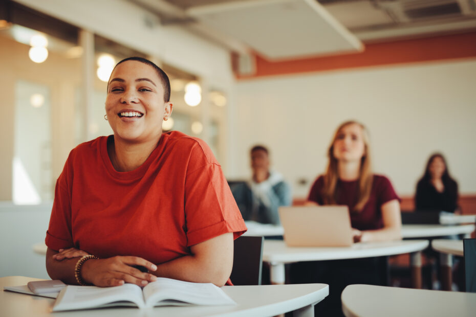 Smiling student sitting in university classroom