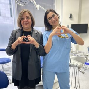 Elham Emami, Dean of the Faculty of Dental Medicine and Oral Health Sciences, and a student both forming the #InspireInclusion heart pose with their hands.