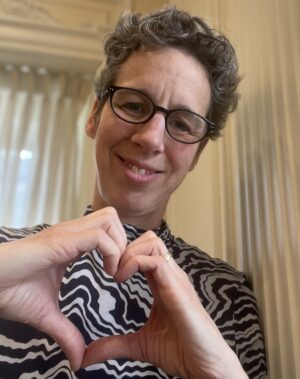 Lesley Fellows, Dean of the Faculty of Medicine and Health Sciences, forming the #InspireInclusion heart pose with her hands.