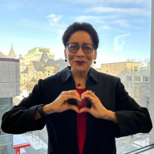 Yolande E. Chan, Dean of the Desautels Faculty of Management, forming the #InspireInclusion heart pose with her hands.