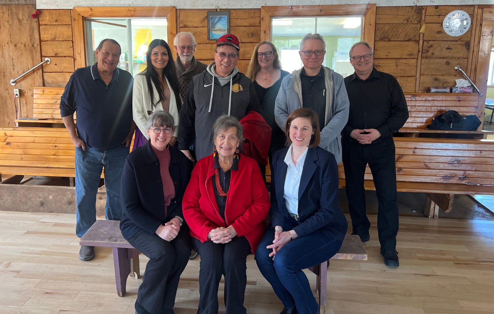10 members of the Task Force on Indigenous Rematriation, Repatriation and Restitution pose in a log cabin.