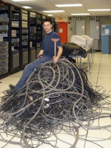 Contractor Pascal Perron of the State Group declares victory over reams of dead cabling he helped pull from under the McGill Data Centre. / Photo: Quan Nguyen