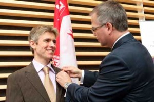 Andrew Reader (left) receives his Canada Research Chair pin from Gary Goodyear, Minister of State (Science and Technology). / Photo: Owen Egan