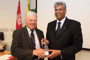 Marc Bieler receives a gift of James McGill crystal from Faculty of Agricultural and Environmental Sciences Dean Chandra Madramootoo. / Photo: Owen Egan